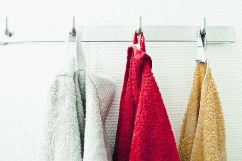 बाथरूम में एक हुक पर एक पंक्ति में तौलिया लटका हुआ है