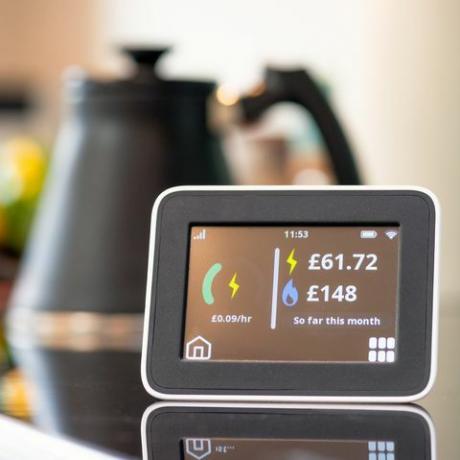 किचन में स्मार्ट मीटर डिस्प्ले की स्क्रीन का क्लोज़ अप, अब तक की बिजली और गैस की मासिक लागत दिखा रहा है